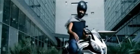 Fiorello durante la sua pubblicità, usa un casco AXO e una splendida moto Aprilia RSV4R